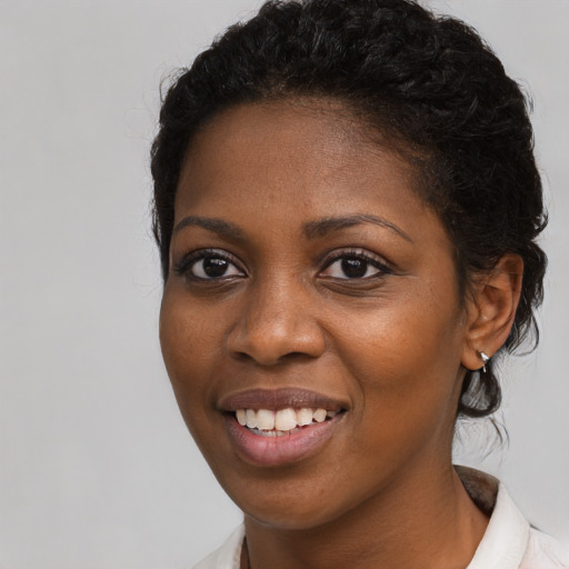Joyful black young-adult female with long  brown hair and brown eyes