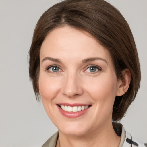 Joyful white young-adult female with medium  brown hair and grey eyes