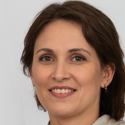 Joyful white adult female with medium  brown hair and brown eyes