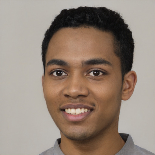 Joyful black young-adult male with short  black hair and brown eyes