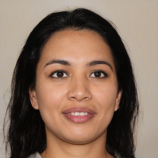 Joyful latino young-adult female with long  black hair and brown eyes