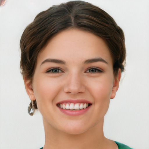 Joyful white young-adult female with short  brown hair and green eyes