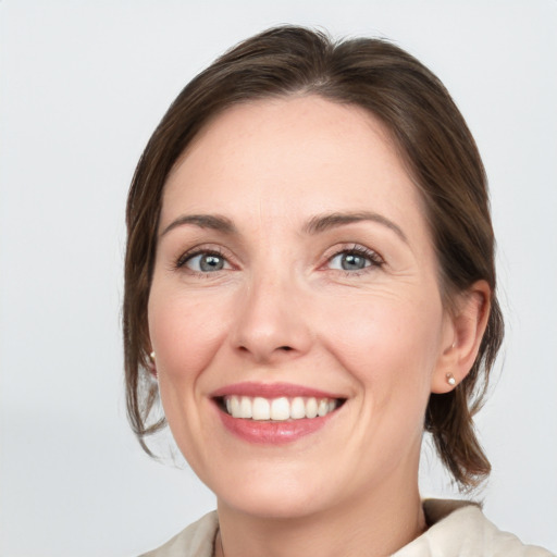 Joyful white adult female with medium  brown hair and grey eyes