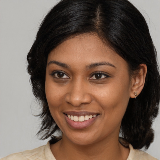 Joyful black young-adult female with medium  brown hair and brown eyes