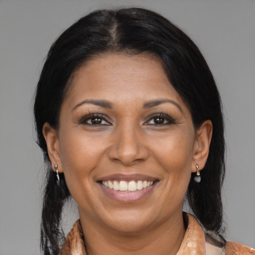 Joyful black adult female with medium  brown hair and brown eyes