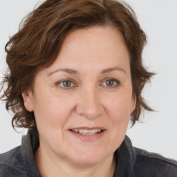 Joyful white adult female with medium  brown hair and grey eyes