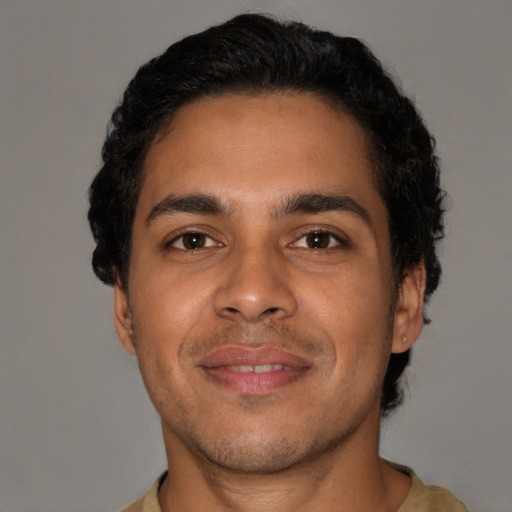 Joyful latino young-adult male with short  brown hair and brown eyes