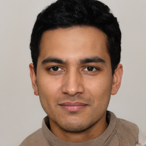 Joyful latino young-adult male with short  black hair and brown eyes