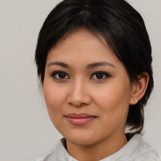 Joyful asian young-adult female with medium  brown hair and brown eyes