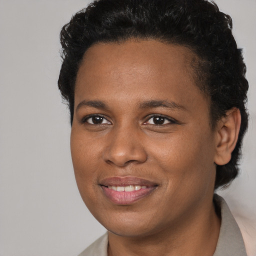 Joyful black young-adult female with short  brown hair and brown eyes
