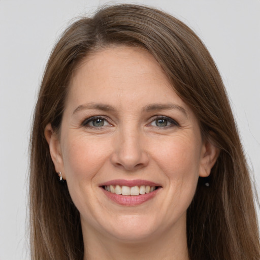 Joyful white adult female with long  brown hair and grey eyes