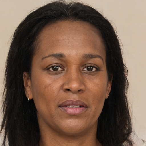 Joyful black adult female with long  brown hair and brown eyes