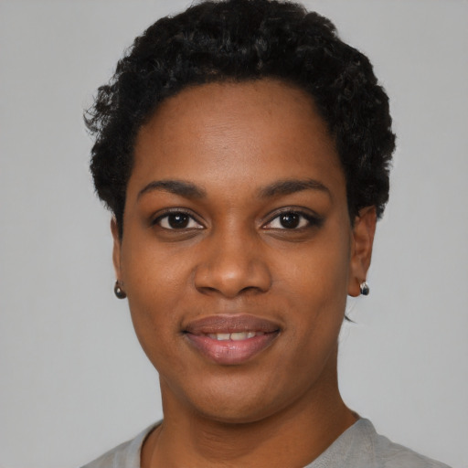 Joyful black young-adult female with short  black hair and brown eyes
