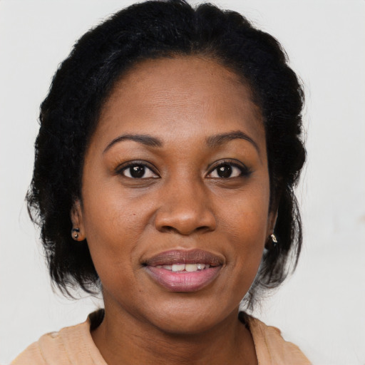 Joyful black adult female with long  brown hair and brown eyes