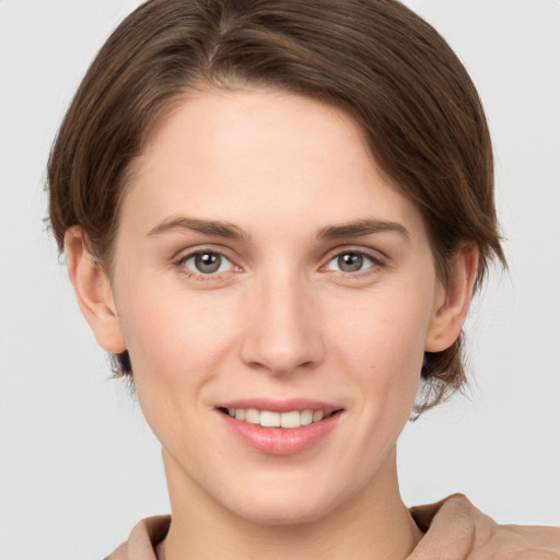 Joyful white young-adult female with short  brown hair and grey eyes