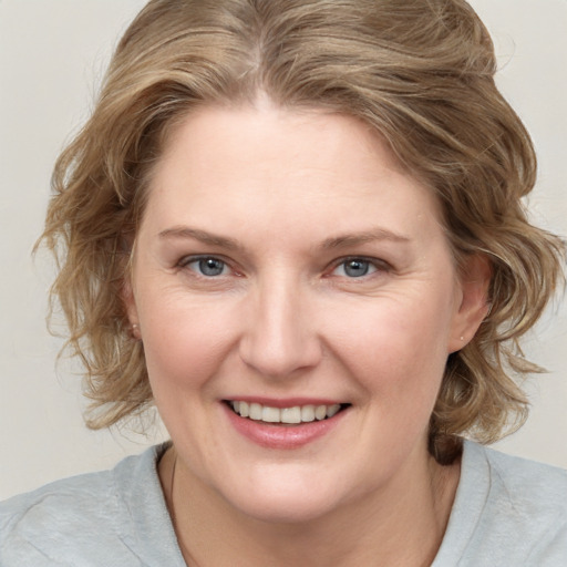 Joyful white young-adult female with medium  brown hair and blue eyes