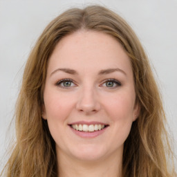 Joyful white young-adult female with long  brown hair and green eyes