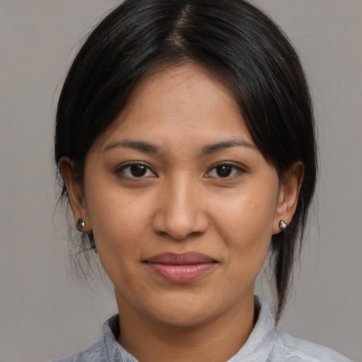 Joyful latino young-adult female with medium  brown hair and brown eyes