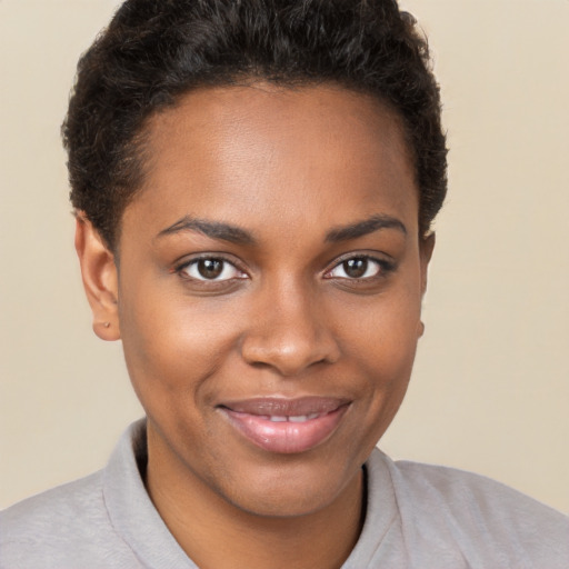 Joyful black young-adult female with short  brown hair and brown eyes