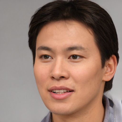Joyful asian young-adult male with medium  brown hair and brown eyes