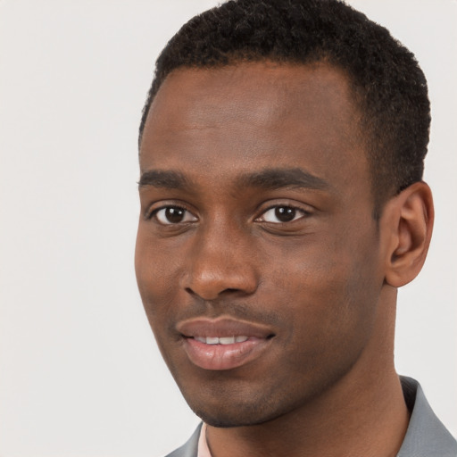 Joyful black young-adult male with short  brown hair and brown eyes