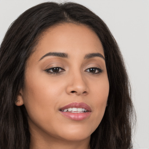 Joyful latino young-adult female with long  brown hair and brown eyes