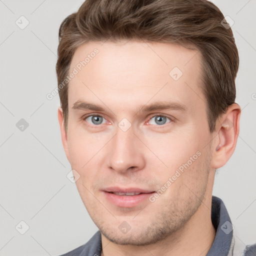 Joyful white young-adult male with short  brown hair and grey eyes