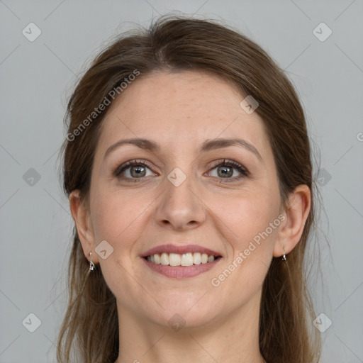 Joyful white adult female with long  brown hair and grey eyes