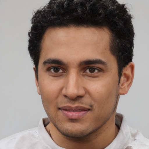Joyful latino young-adult male with short  black hair and brown eyes
