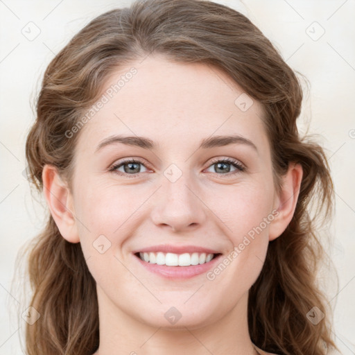 Joyful white young-adult female with long  brown hair and blue eyes