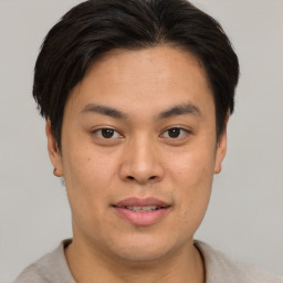 Joyful asian young-adult male with short  brown hair and brown eyes