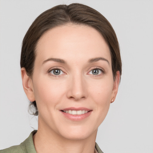 Joyful white young-adult female with medium  brown hair and grey eyes