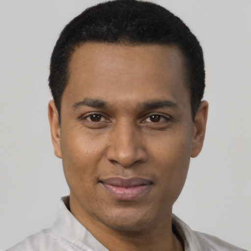 Joyful black young-adult male with short  black hair and brown eyes