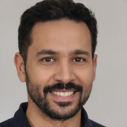 Joyful latino young-adult male with short  black hair and brown eyes