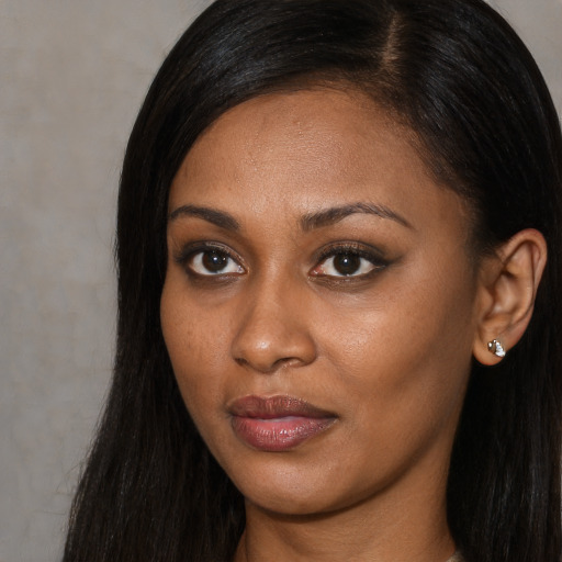 Joyful black young-adult female with long  brown hair and brown eyes