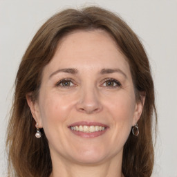 Joyful white adult female with long  brown hair and grey eyes