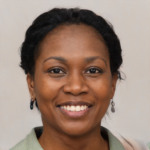 Joyful black adult female with short  black hair and brown eyes