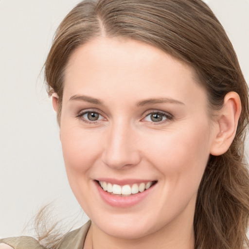 Joyful white young-adult female with long  brown hair and blue eyes