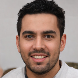 Joyful white young-adult male with short  black hair and brown eyes