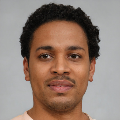 Joyful latino young-adult male with short  brown hair and brown eyes