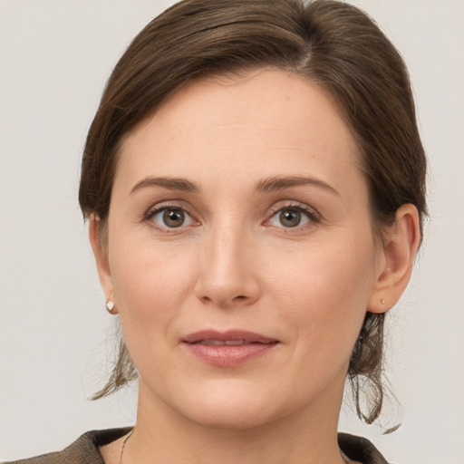 Joyful white young-adult female with medium  brown hair and grey eyes