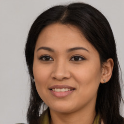 Joyful latino young-adult female with long  brown hair and brown eyes