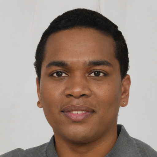 Joyful black young-adult male with short  black hair and brown eyes