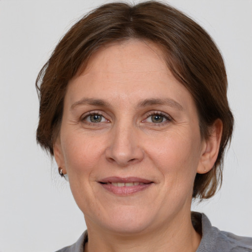 Joyful white adult female with medium  brown hair and grey eyes