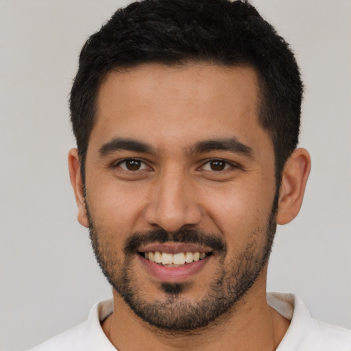 Joyful latino young-adult male with short  black hair and brown eyes