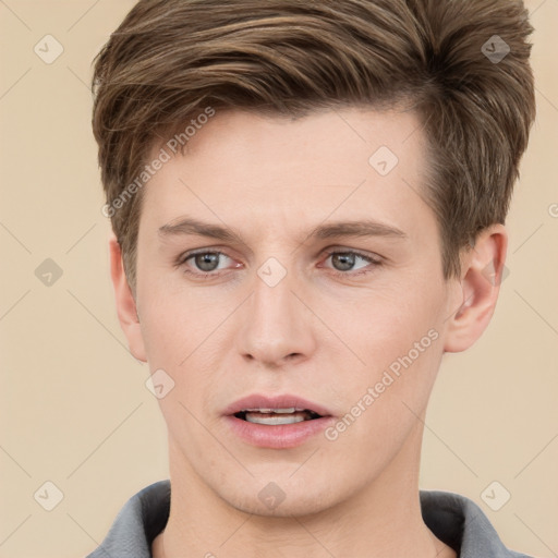 Joyful white young-adult male with short  brown hair and grey eyes