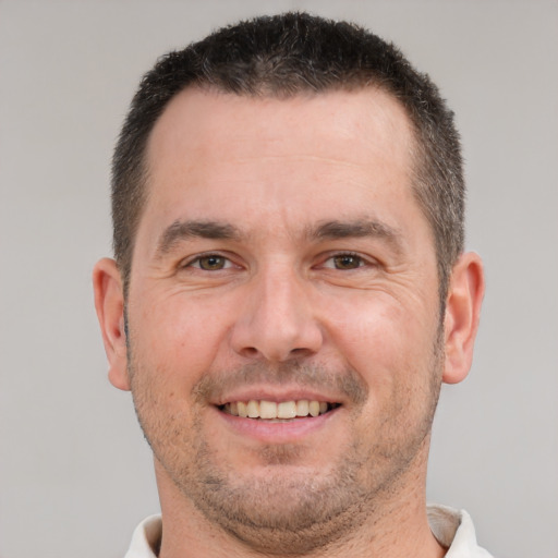 Joyful white adult male with short  brown hair and brown eyes