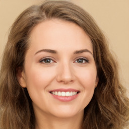 Joyful white young-adult female with long  brown hair and green eyes