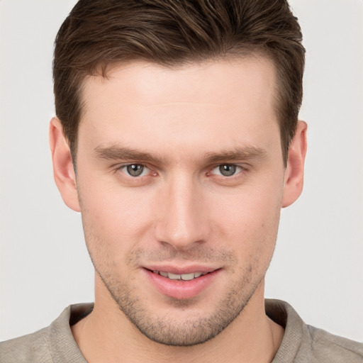 Joyful white young-adult male with short  brown hair and grey eyes