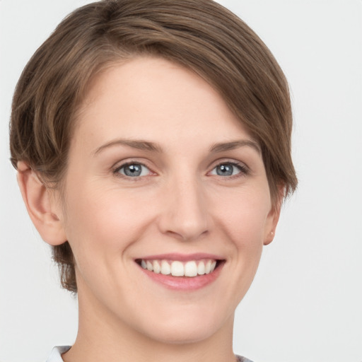 Joyful white young-adult female with short  brown hair and grey eyes